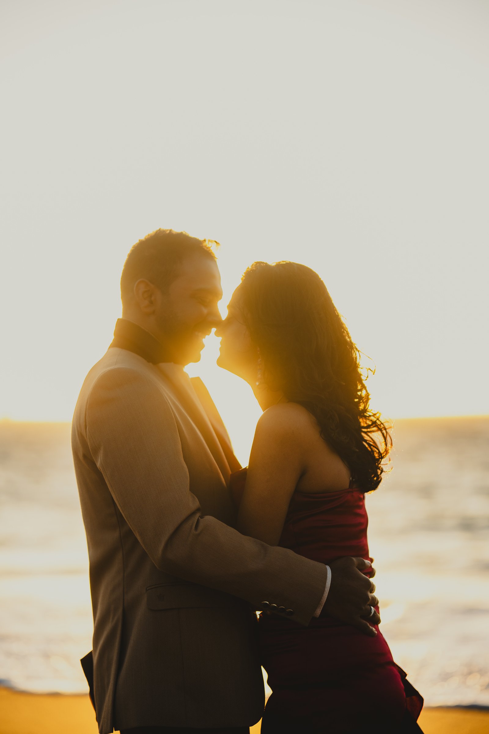Karthika and Bharath at the water's edge at sunset